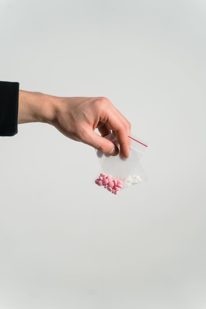 Conceptual image of a hand holding a bag with pills representing addiction issues.