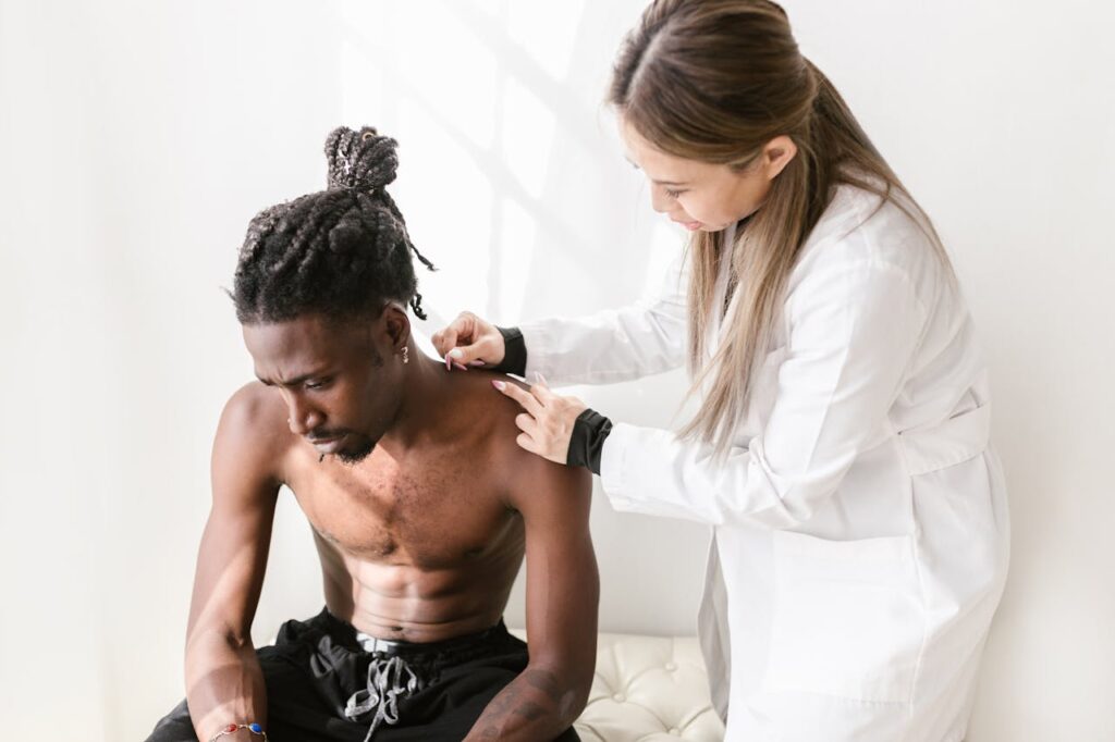 A therapist performs acupuncture on a patient for pain relief in a modern setting.